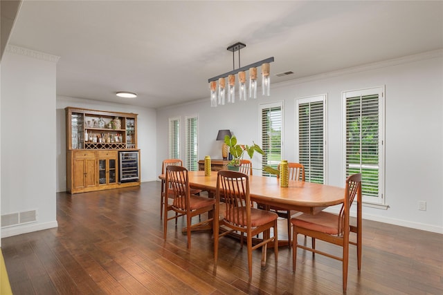 3212 Woodwind Ln, Dallas, TX 75229 - dining space with wine cooler, a dry bar, dark wood-style floors, crown molding, and baseboards