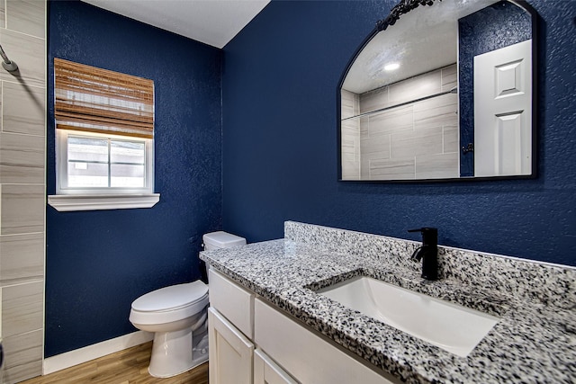 6225 Kentwood Pl, Fort Worth, TX 76112 - full bath featuring wood finished floors, toilet, a textured wall, baseboards, and vanity