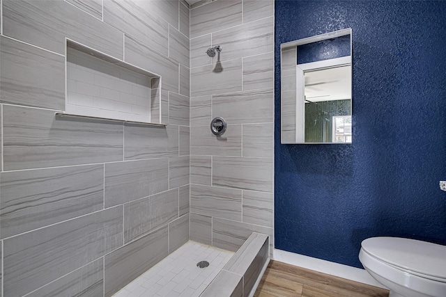 6225 Kentwood Pl, Fort Worth, TX 76112 - full bath with a tile shower, toilet, a textured wall, and wood finished floors