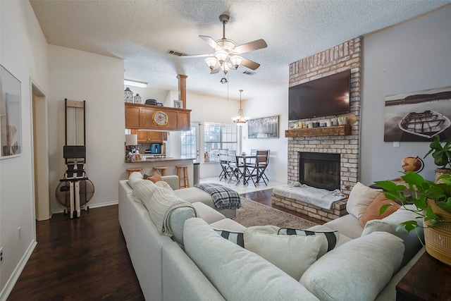 1112 Bayfield Dr, Denton, TX 76209 - living room featuring ceiling fan, a textured ceiling, dark wood finished floors, baseboards, and a brick fireplace