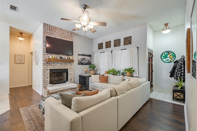 1112 Bayfield Dr, Denton, TX 76209 - living room featuring ceiling fan, wood finished floors, a textured ceiling, a fireplace, and baseboards