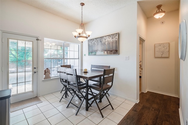 1112 Bayfield Dr, Denton, TX 76209 - dining area with a chandelier, a textured ceiling, baseboards, and light tile patterned floors