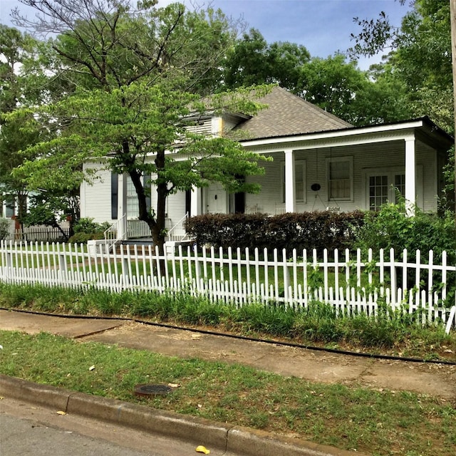 1014 N Sycamore St, Palestine, TX 75801 - view of front of property featuring covered porch, a fenced front yard, and roof with shingles