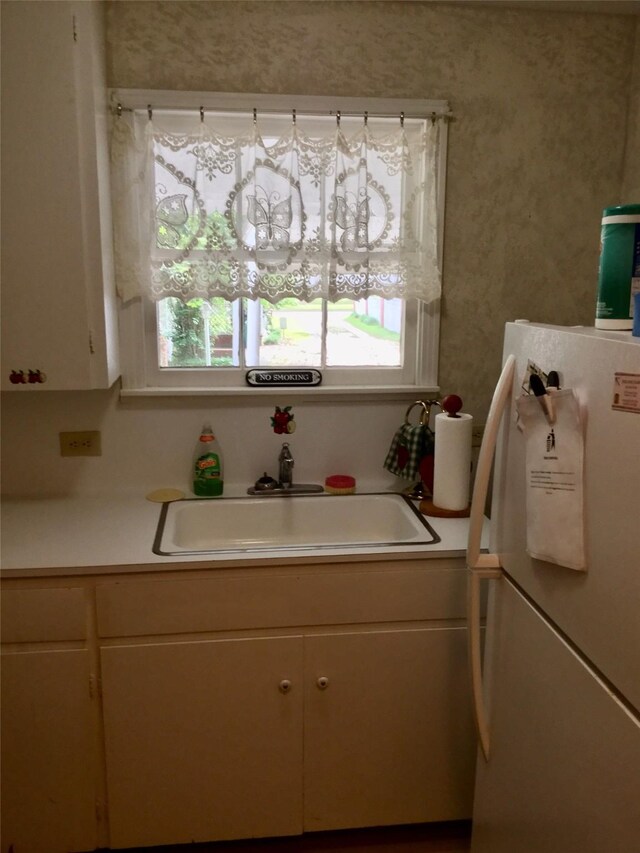 1014 N Sycamore St, Palestine, TX 75801 - kitchen with freestanding refrigerator, light countertops, healthy amount of natural light, and a sink