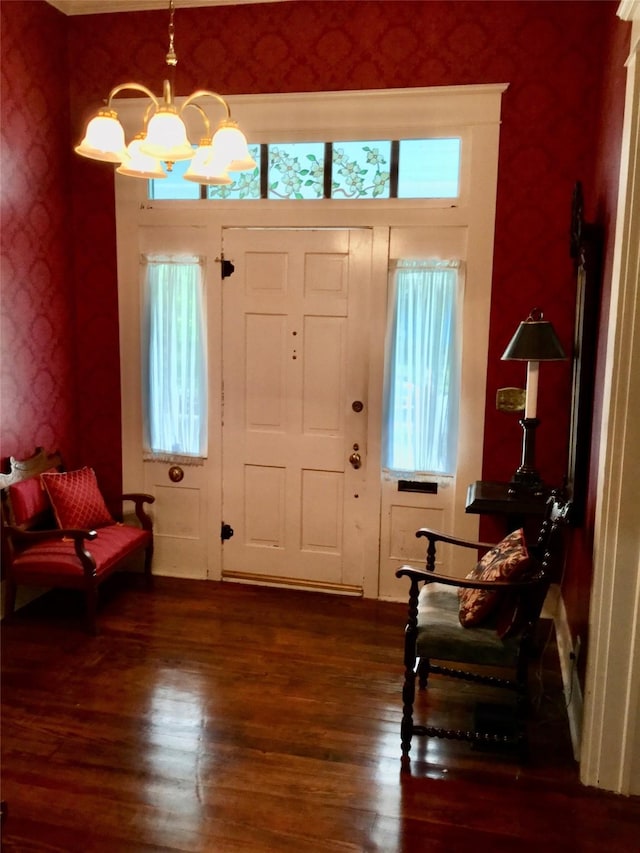 1014 N Sycamore St, Palestine, TX 75801 - entryway with wallpapered walls, a chandelier, and wood finished floors