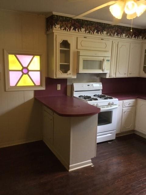 1014 N Sycamore St, Palestine, TX 75801 - kitchen featuring white appliances, a peninsula, dark wood-style floors, white cabinets, and glass insert cabinets
