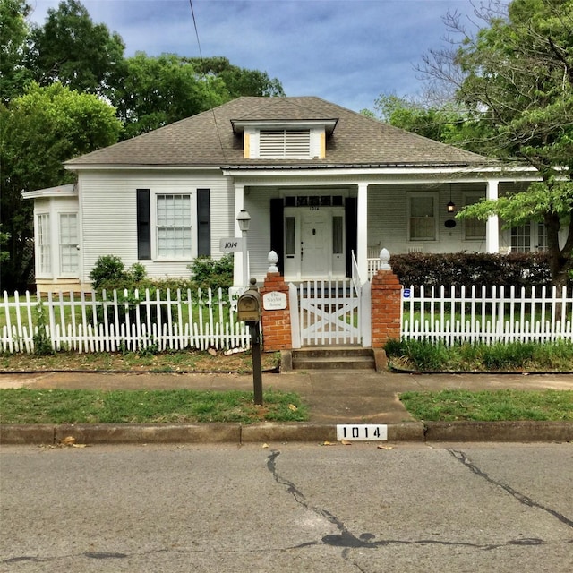 1014 N Sycamore St, Palestine, TX 75801 - bungalow with covered porch, a fenced front yard, and a shingled roof