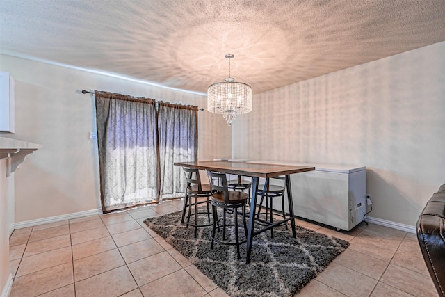 8110 Macgregor Dr, Arlington, TX 76002 - dining area featuring tile patterned flooring, a chandelier, baseboards, and a textured ceiling