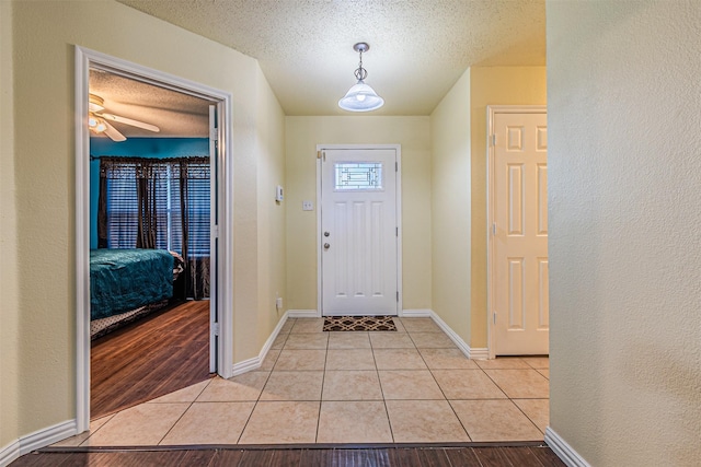 8110 Macgregor Dr, Arlington, TX 76002 - entrance foyer with light tile patterned floors, a textured ceiling, baseboards, and a ceiling fan