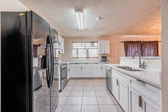 8110 Macgregor Dr, Arlington, TX 76002 - kitchen featuring stainless steel appliances, a sink, a textured ceiling, light tile patterned flooring, and white cabinetry