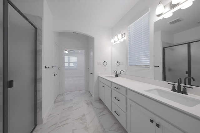 2301 Miramar Dr, Little Elm, TX 75068 - full bath featuring marble look tile flooring, a stall shower, double vanity, a ceiling fan, and baseboards