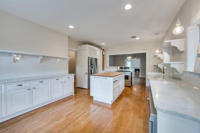 1138 N Windomere Ave, Dallas, TX 75208 - kitchen with appliances with stainless steel finishes, wooden counters, open shelves, decorative backsplash, and white cabinets