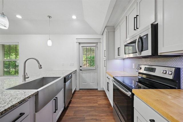 930 Baker St, Denison, TX 75020 - kitchen featuring appliances with stainless steel finishes, a sink, lofted ceiling, dark wood-style flooring, and decorative backsplash