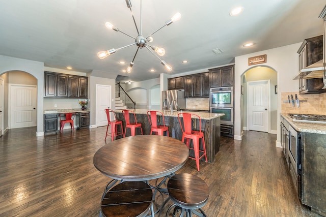 1005 Caudle Ln, Savannah, TX 76227 - dining area with arched walkways, dark wood-style floors, recessed lighting, and a chandelier