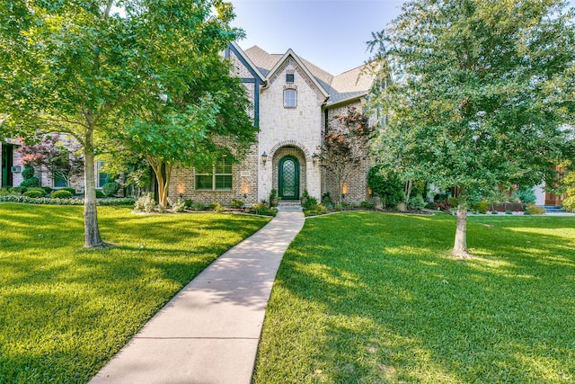 view of front of house with stone siding, a front lawn, and brick siding