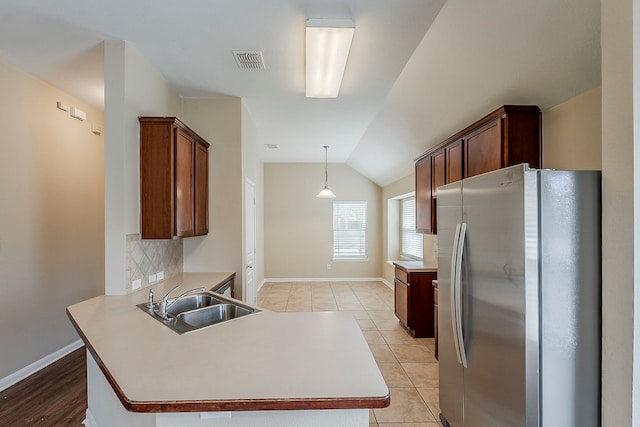12113 Tacoma Ridge Dr, Fort Worth, TX 76244 - kitchen with freestanding refrigerator, a sink, a peninsula, vaulted ceiling, and baseboards