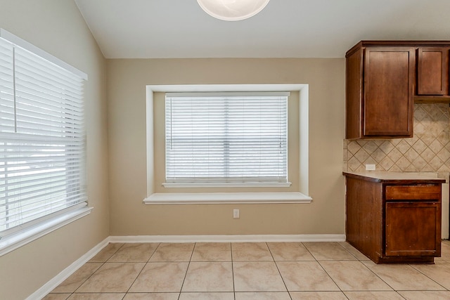 12113 Tacoma Ridge Dr, Fort Worth, TX 76244 - unfurnished dining area with light tile patterned flooring, baseboards, and lofted ceiling