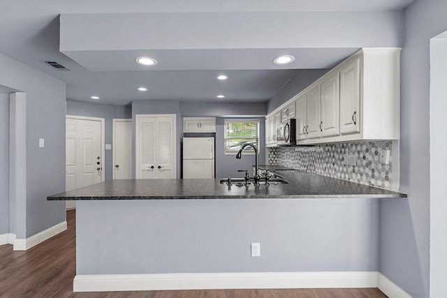 154 Henry M Chandler Dr, Rockwall, TX 75032 - kitchen with freestanding refrigerator, a sink, a peninsula, stainless steel microwave, and dark countertops