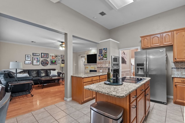 kitchen with stainless steel appliances, open floor plan, light tile patterned floors, ceiling fan, and crown molding