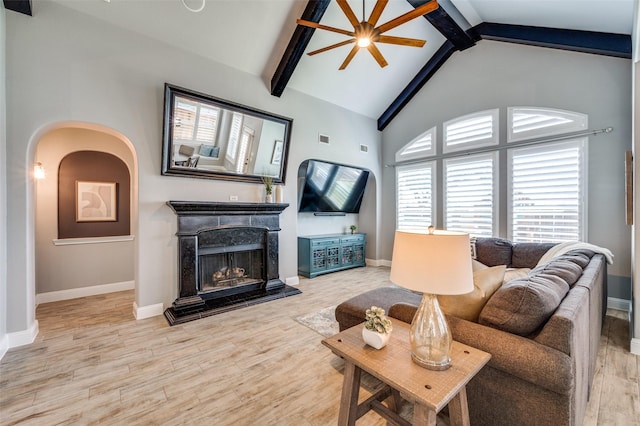 1912 Sunny Side Dr, Little Elm, TX 75068 - living room with beamed ceiling, baseboards, wood finished floors, a fireplace with raised hearth, and high vaulted ceiling
