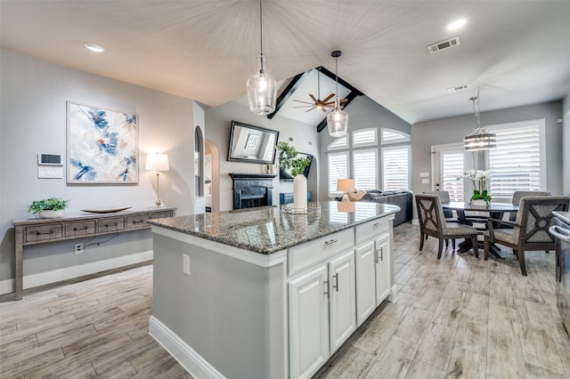 1912 Sunny Side Dr, Little Elm, TX 75068 - kitchen featuring open floor plan, light wood finished floors, a fireplace, light stone counters, and white cabinetry