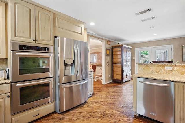 4322 Glenaire Dr, Dallas, TX 75229 - kitchen with appliances with stainless steel finishes, decorative backsplash, wood finished floors, recessed lighting, and cream cabinetry