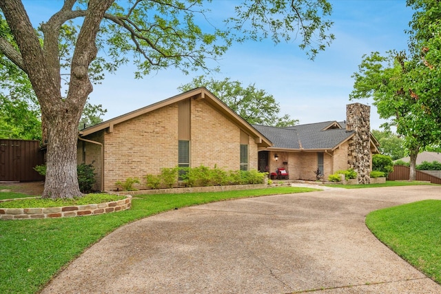 4322 Glenaire Dr, Dallas, TX 75229 - mid-century home with brick siding, a chimney, and curved driveway