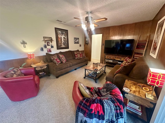 922 S Valentine Dr, Sherman, TX 75090 - carpeted living room with wood walls, a textured ceiling, and a ceiling fan