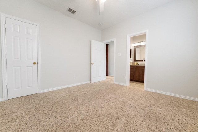 unfurnished bedroom with light colored carpet, ensuite bathroom, and baseboards