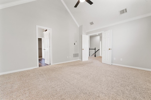 carpeted spare room with ceiling fan, high vaulted ceiling, ornamental molding, and baseboards