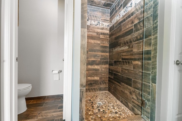 full bathroom with a stall shower, toilet, and wood finished floors