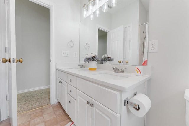 bathroom with double vanity and baseboards