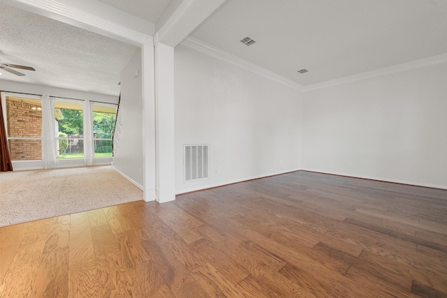 empty room with ceiling fan, wood finished floors, baseboards, and ornamental molding