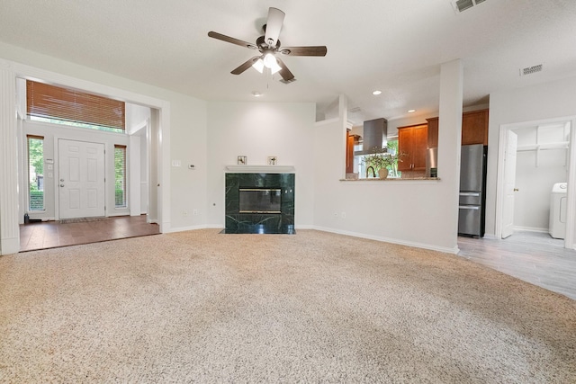 unfurnished living room with washer / clothes dryer, carpet floors, a ceiling fan, baseboards, and recessed lighting