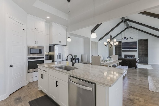 2720 Creek Crossing Ln, Midlothian, TX 76065 - kitchen featuring stainless steel appliances, a sink, open floor plan, an island with sink, and white cabinets
