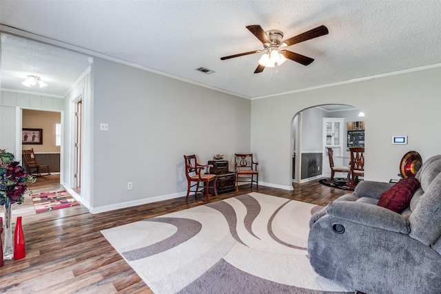 2614 Ivandell Ave, Dallas, TX 75211 - living room with arched walkways, wood finished floors, a textured ceiling, crown molding, and ceiling fan