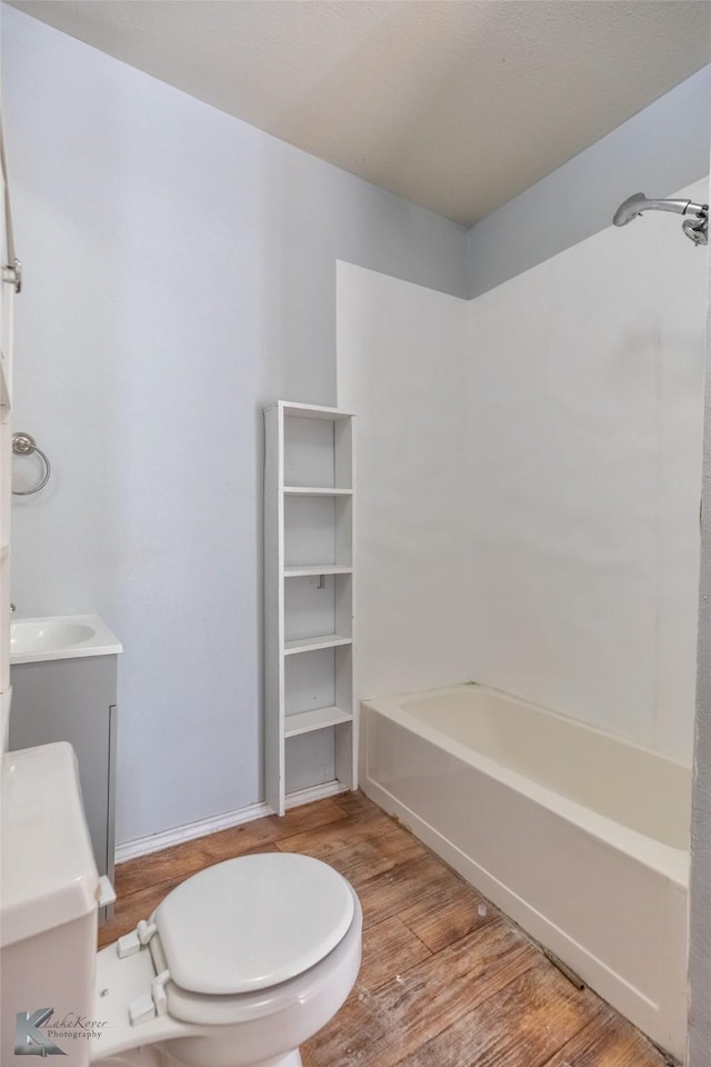 1810 Merchant St, Abilene, TX 79603 - full bath with wood finished floors, toilet, shower / tub combination, vanity, and baseboards