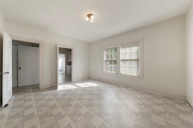 2701 Ethel Ave, Waco, TX 76707 - unfurnished bedroom featuring a textured ceiling, light flooring, and baseboards