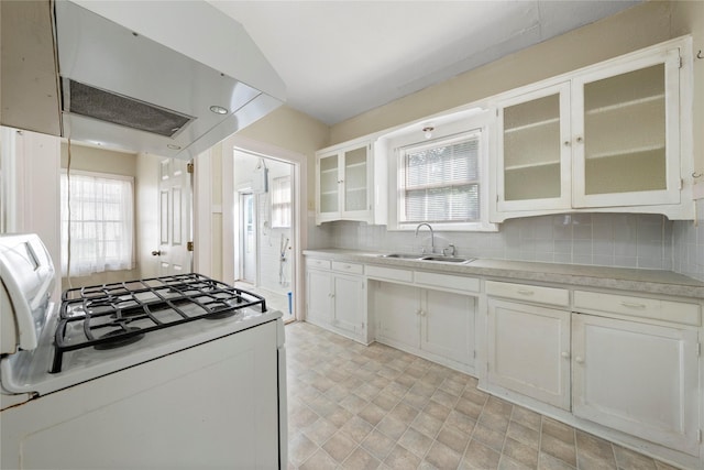 2701 Ethel Ave, Waco, TX 76707 - kitchen with white gas stove, a sink, under cabinet range hood, light countertops, and tasteful backsplash