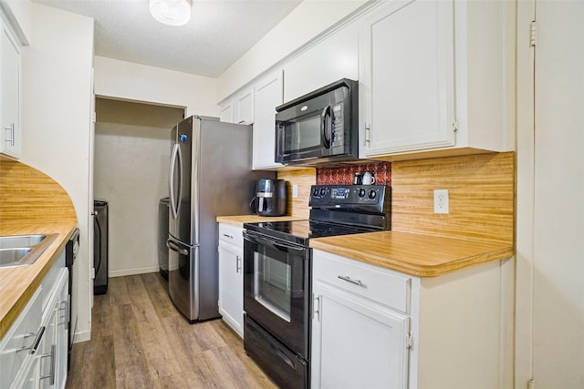 kitchen with black appliances, wood finished floors, tasteful backsplash, white cabinets, and a textured ceiling