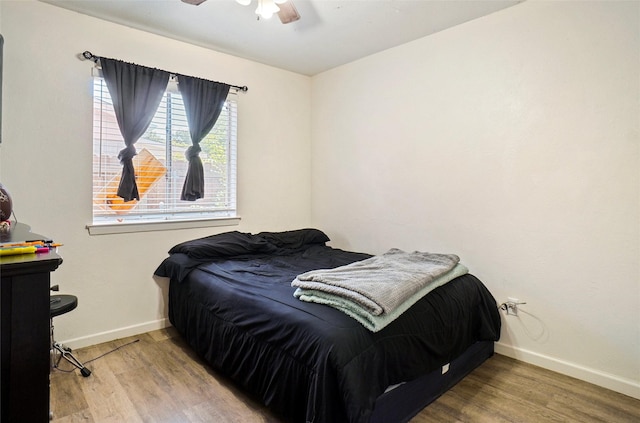 bedroom featuring wood finished floors, baseboards, and a ceiling fan