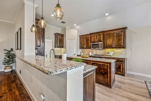 437 Sagebrush Dr, Aledo, TX 76008 - kitchen featuring stainless steel microwave, tasteful backsplash, light wood finished floors, dark brown cabinetry, and baseboards