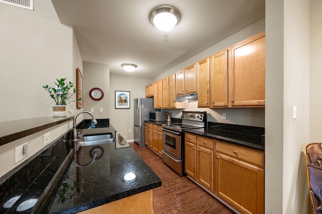 2305 Worthington St Unit 328, Dallas, TX 75204 - kitchen featuring appliances with stainless steel finishes, a sink, under cabinet range hood, dark wood finished floors, and dark stone counters