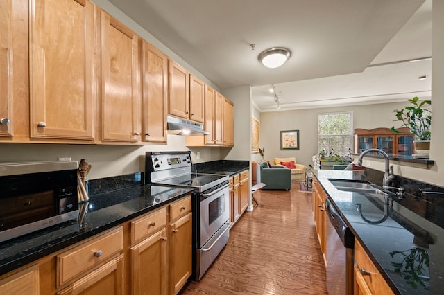 2305 Worthington St Unit 328, Dallas, TX 75204 - kitchen featuring appliances with stainless steel finishes, under cabinet range hood, wood finished floors, open floor plan, and dark stone countertops