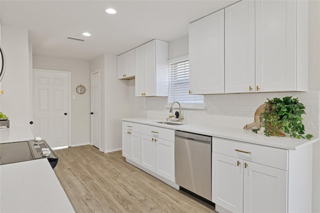 1427 Northridge Dr, Carrollton, TX 75006 - kitchen featuring stainless steel dishwasher, a sink, decorative backsplash, light wood-style floors, and white cabinetry