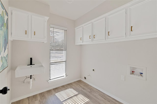 1427 Northridge Dr, Carrollton, TX 75006 - laundry area featuring cabinet space, hookup for a washing machine, light wood finished floors, and electric dryer hookup