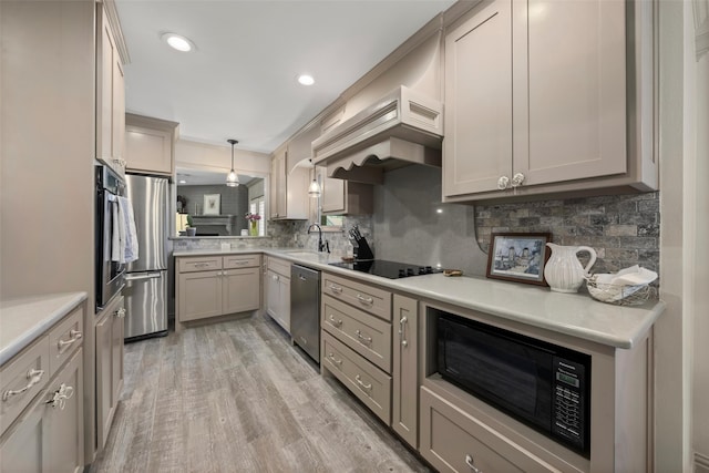 3417 Fern Hill Cir, Waco, TX 76708 - kitchen featuring black appliances, a sink, decorative backsplash, custom exhaust hood, and light wood-style flooring