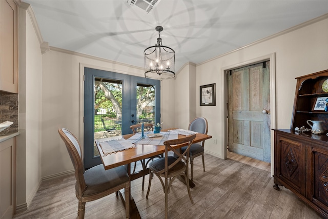 3417 Fern Hill Cir, Waco, TX 76708 - dining area with crown molding, light wood finished floors, a chandelier, french doors, and baseboards