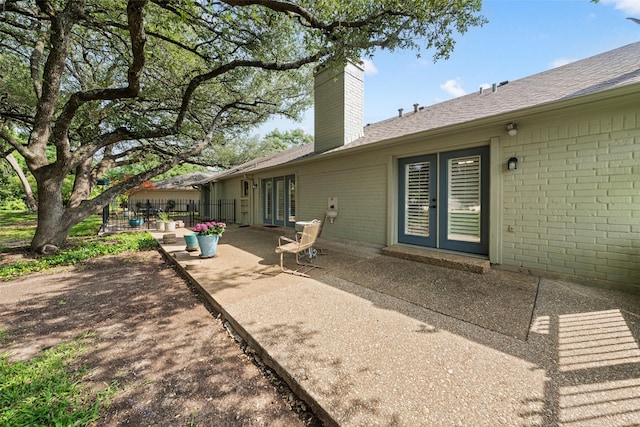 3417 Fern Hill Cir, Waco, TX 76708 - rear view of property with french doors, a chimney, a patio, brick siding, and a shingled roof