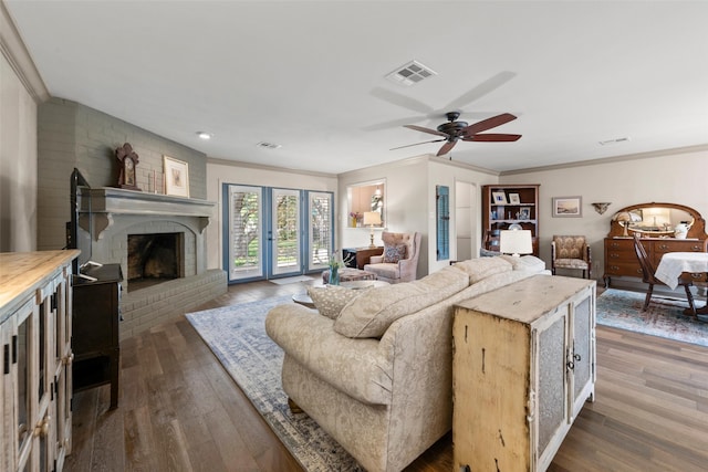 3417 Fern Hill Cir, Waco, TX 76708 - living room featuring crown molding, dark wood finished floors, a ceiling fan, and a brick fireplace